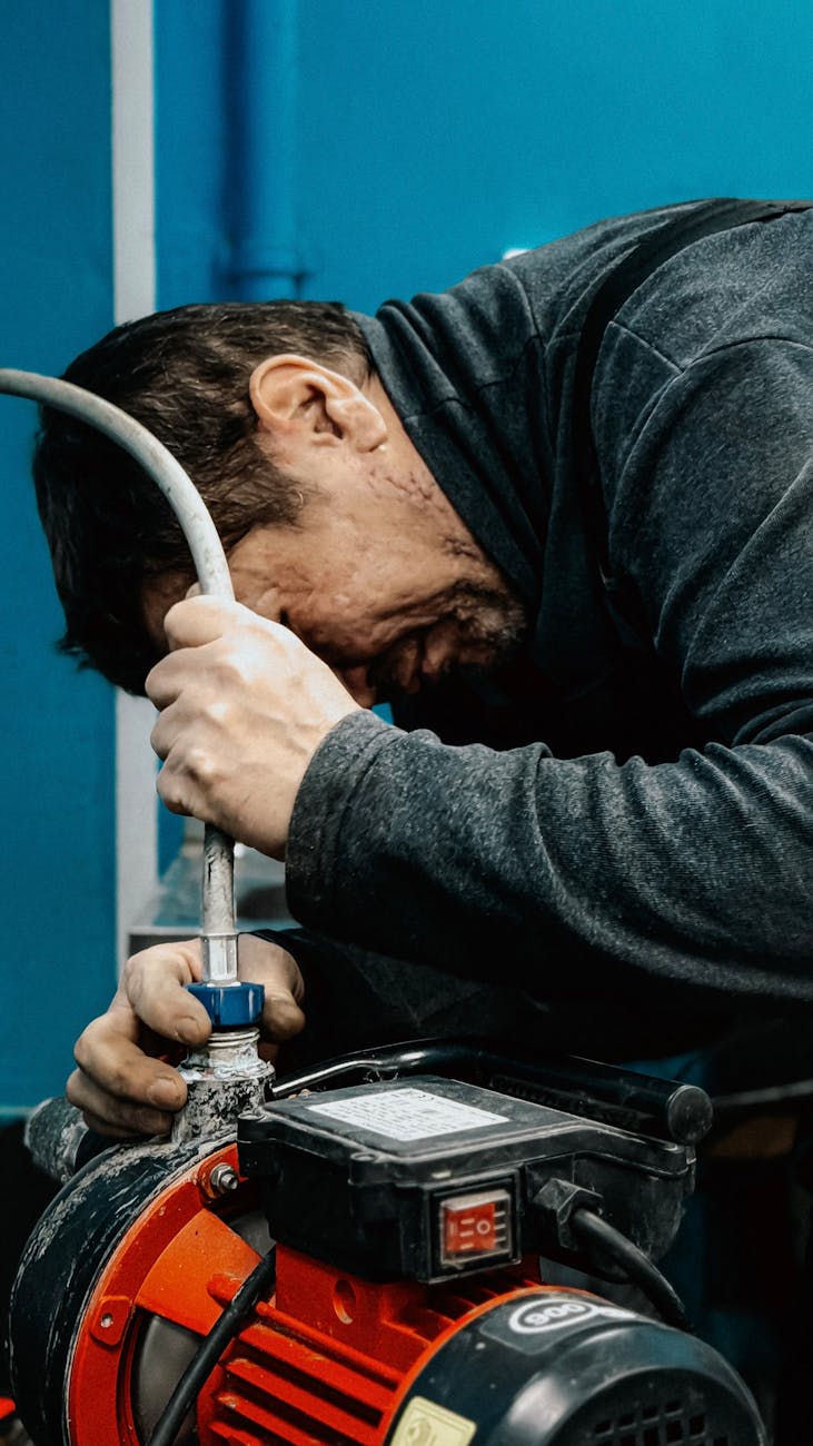 focused technician working with water pump