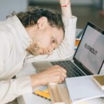 overworked employee lying in front of laptop