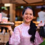 smiling woman with beverages at an outdoor cafe