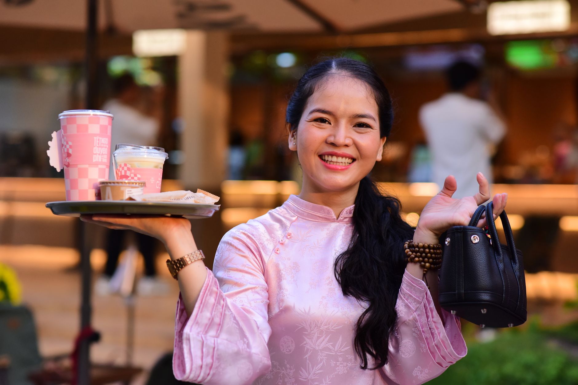 smiling woman with beverages at an outdoor cafe