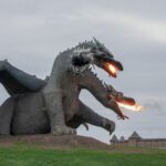 a triple head dragon sculpture in a park