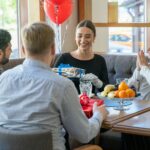 people at the table holding wrapped gifts