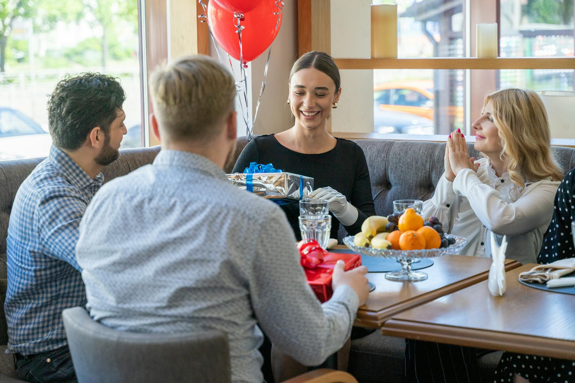 people at the table holding wrapped gifts