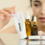 woman touching cream in plastic tube