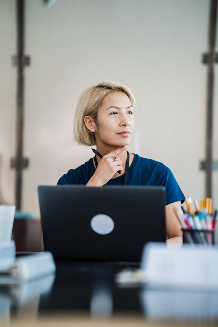 woman thinking while working on laptop