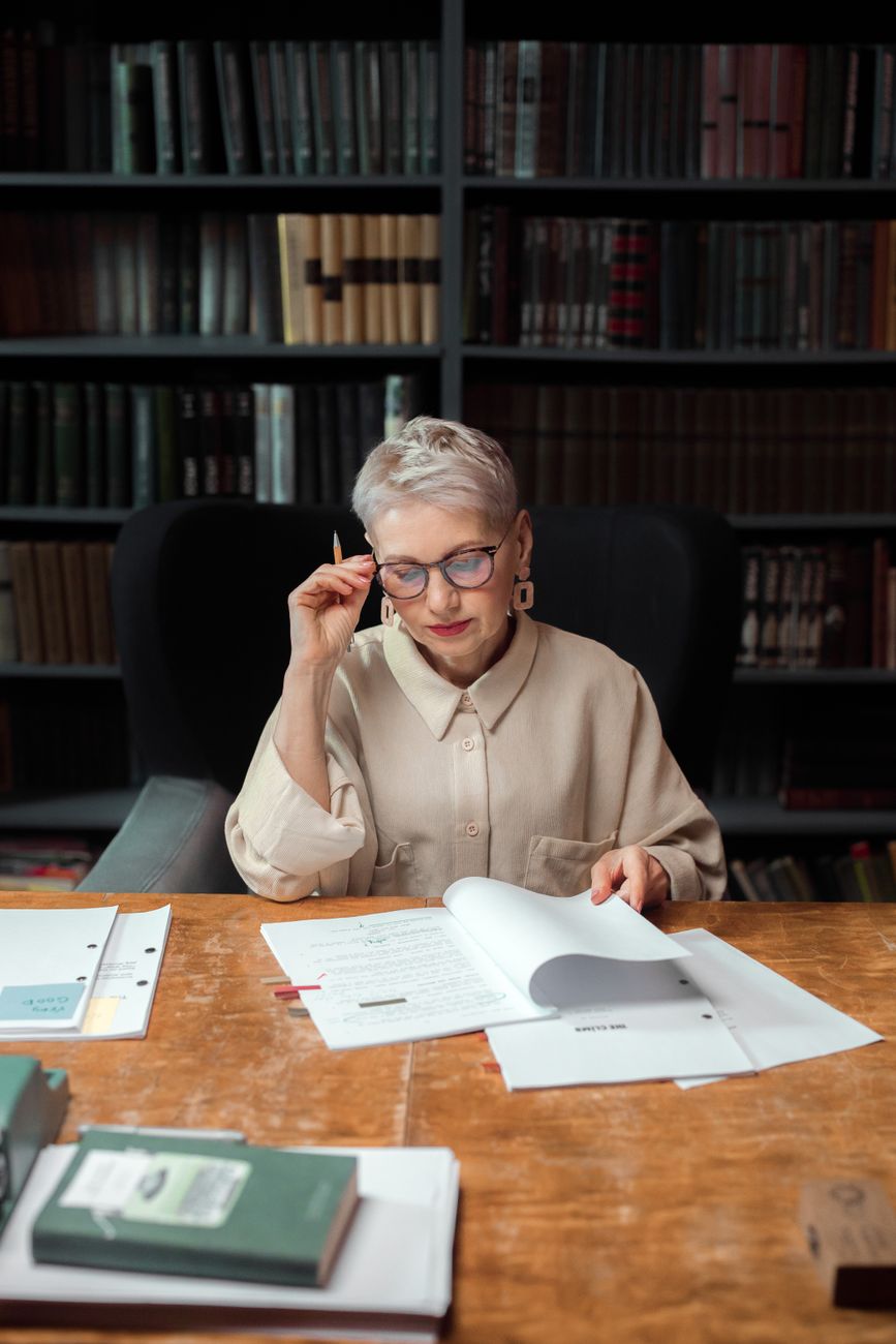 woman sitting on black chair while checking some papers