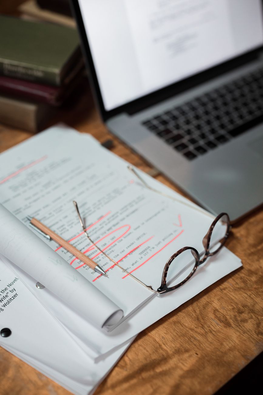 glasses on paperwork and laptop on table